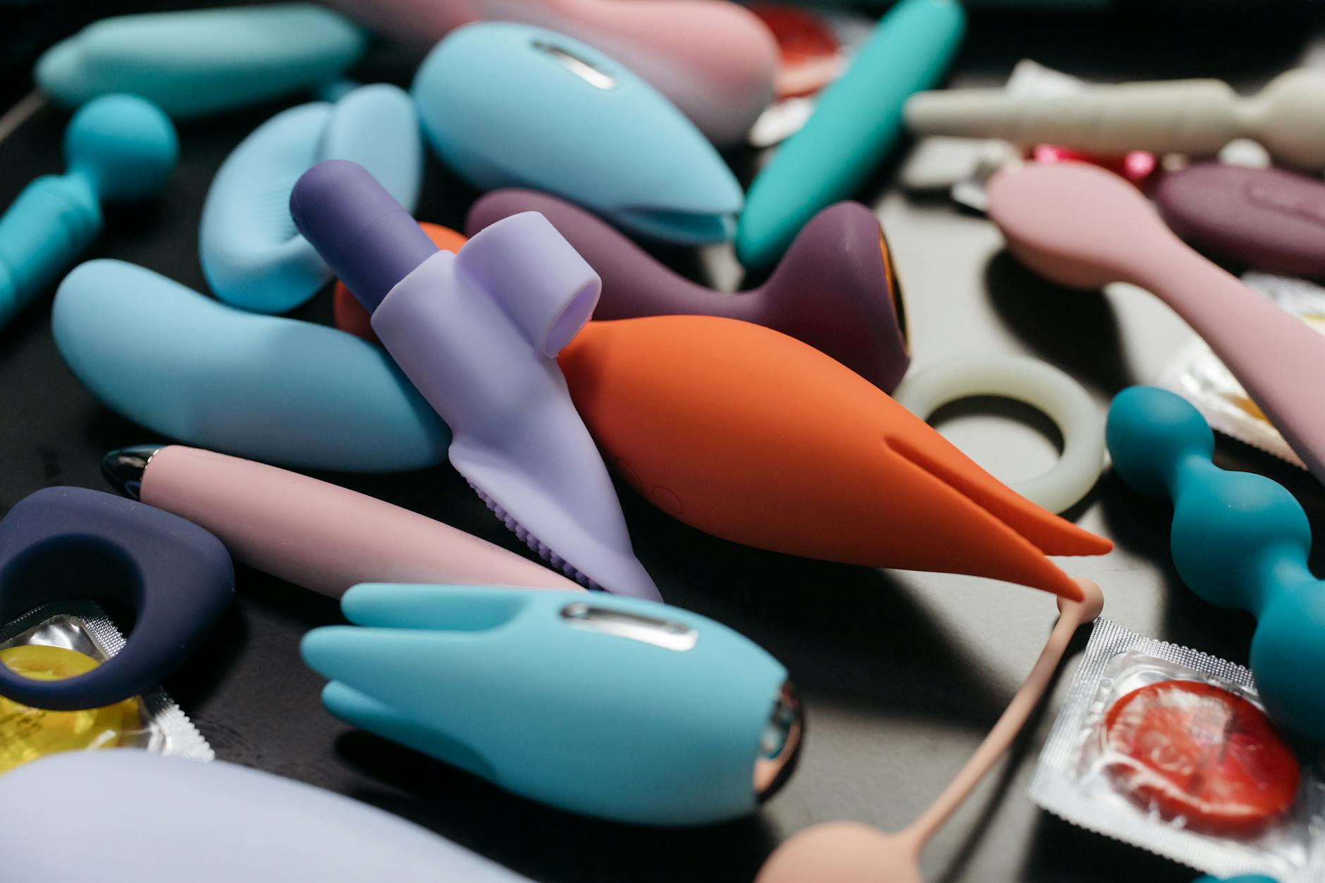 A young couple standing together indoors, holding a blue vibrator, symbolizing modern intimacy