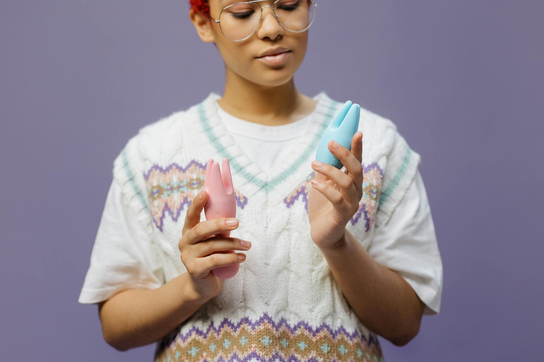 Woman holding clitoral vibrators and contemplating sensations from birth control changes